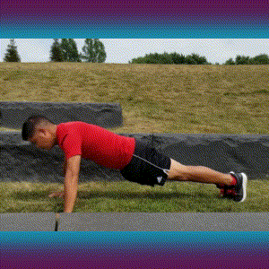 A man doing push-ups on the grass.