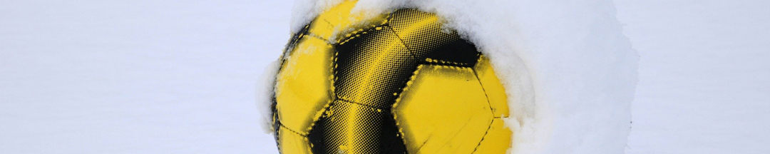 A yellow soccer ball covered in snow.