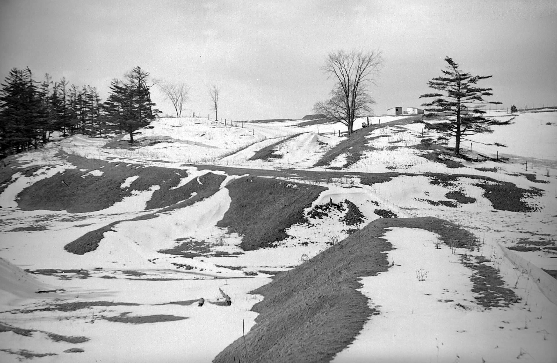 A snowy path going down a slope.
