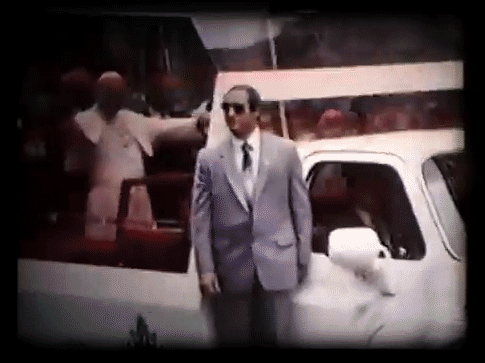 The Pope waving from his Popemobile.