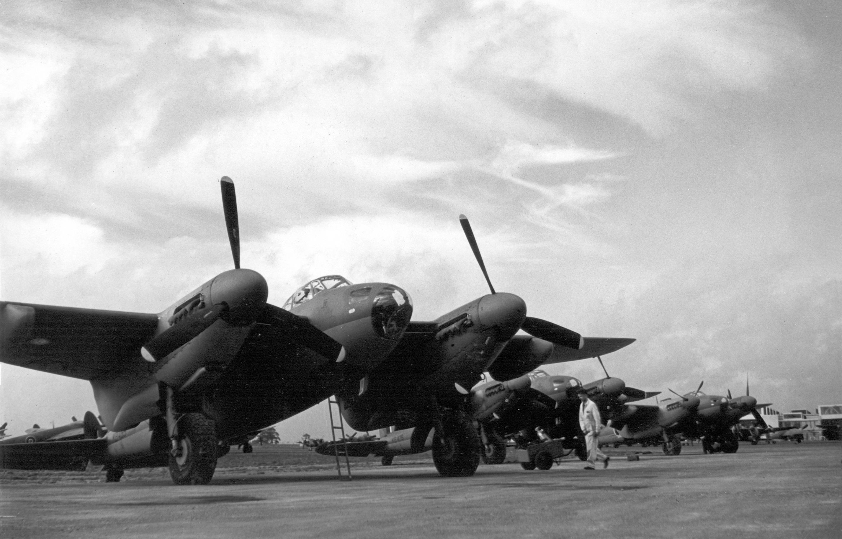 A black and white photo of five aircrafts, all de Havilland Mosquitos, standing in a row.