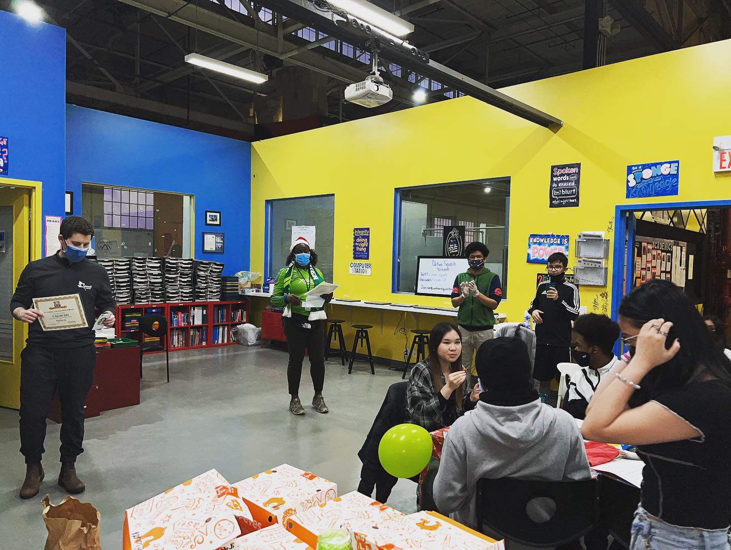 Staff and students enjoying snacks in a classroom.