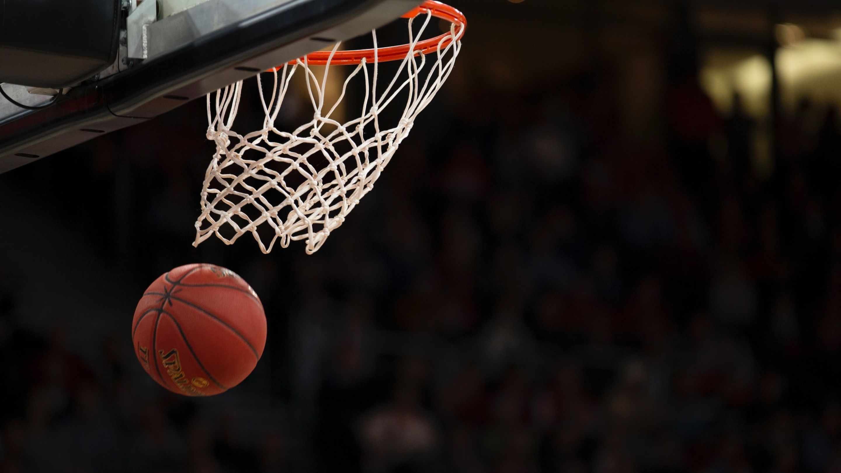 A basketball going through a basketball net. 