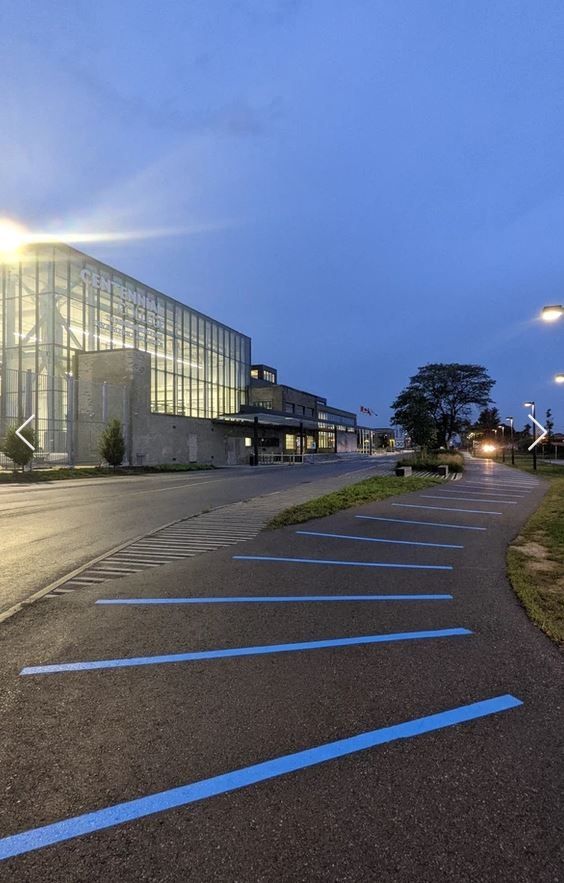 Bright blue lines painted along a paved path. Seneca college to the left.