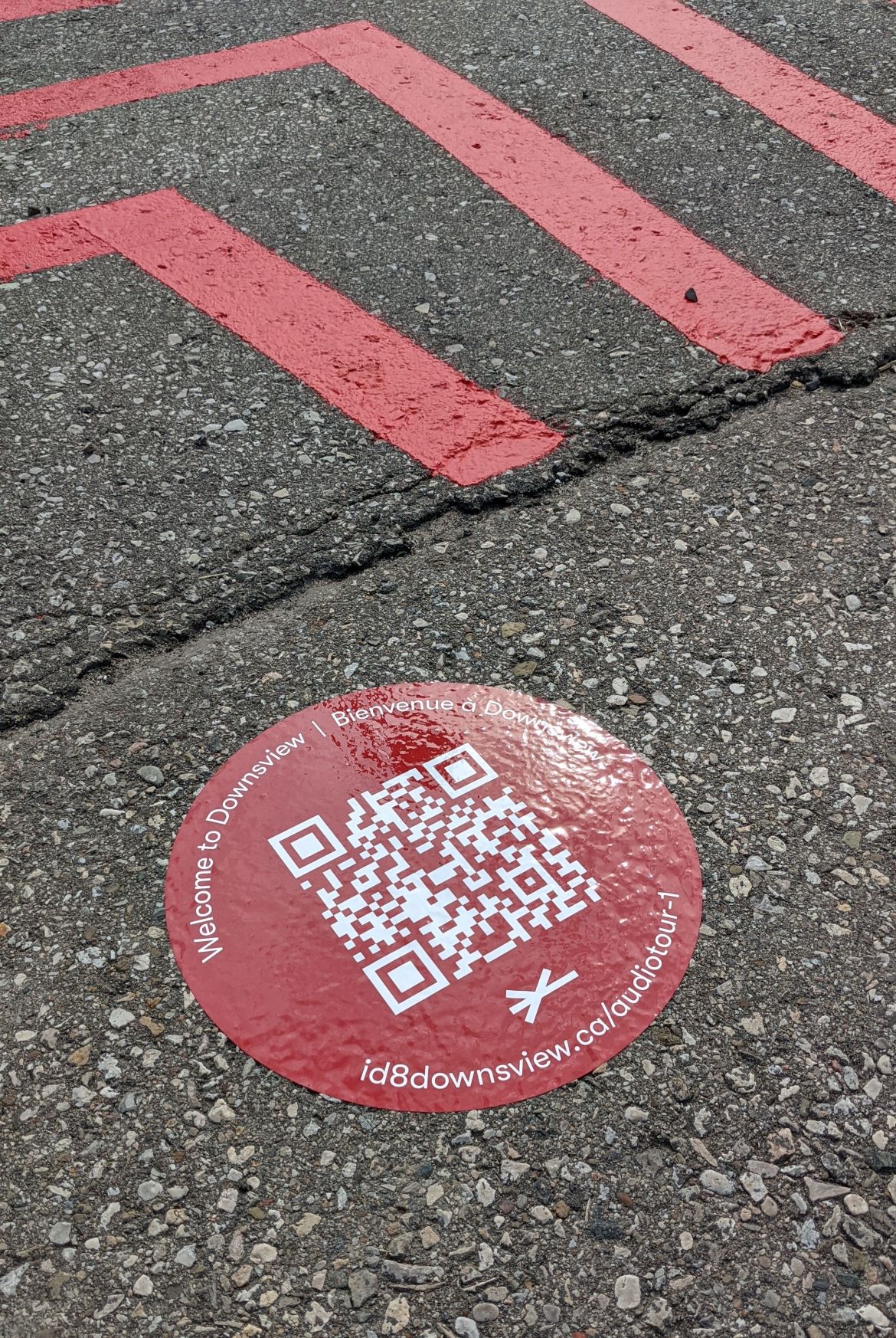 A QR code sticker on a paved path.
