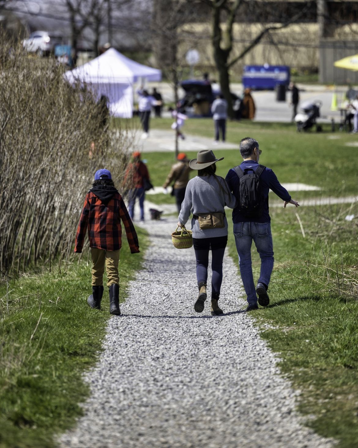 People walking on a path towards the Earth Day festival at Downsview Park.