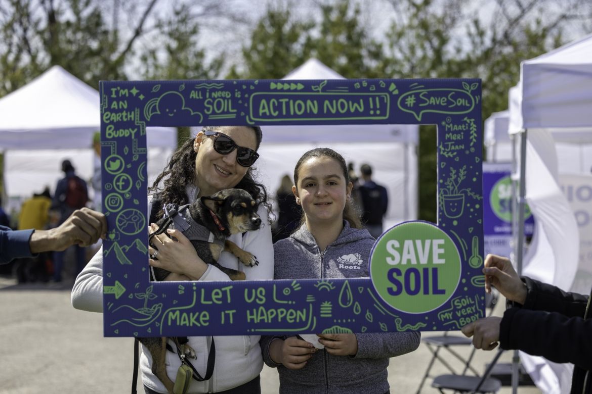 People taking photos at the Save Soil booth.
