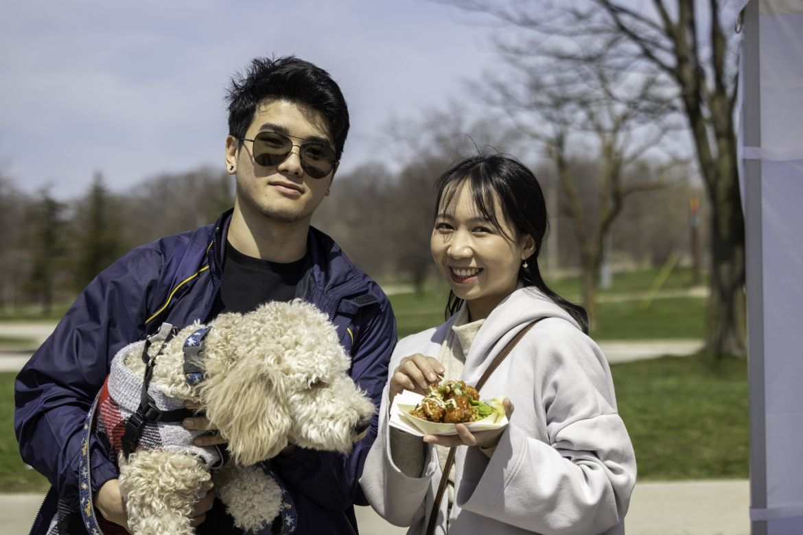 Two people and their dog smiling for the camera.
