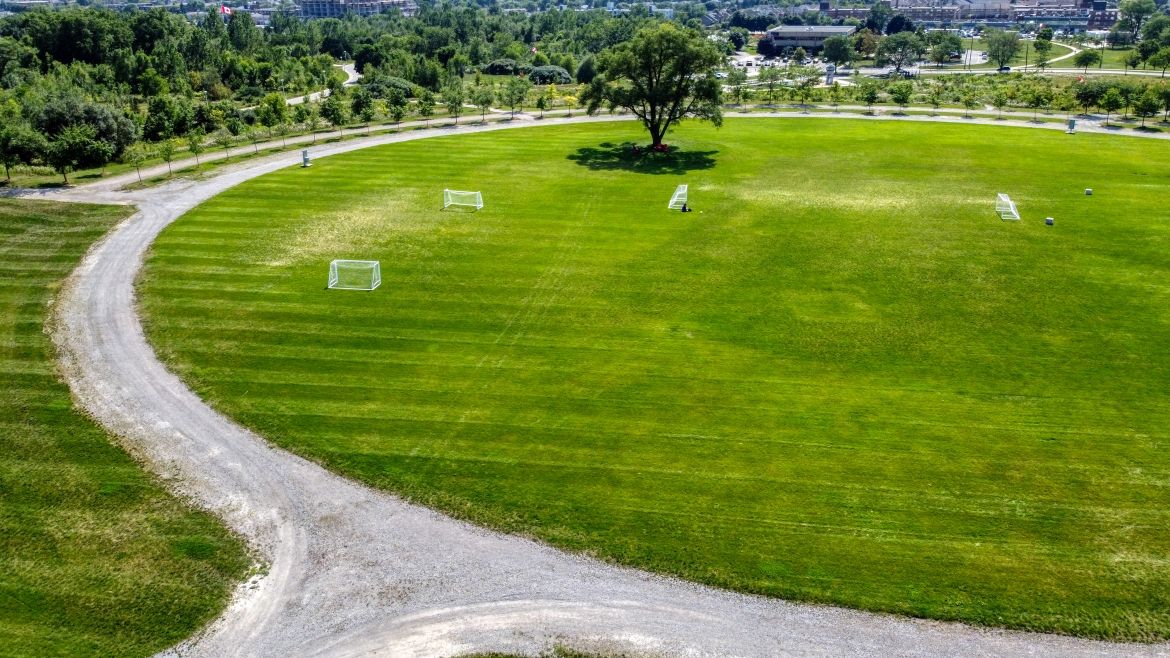 An aerial shot of a circular field with a path going around it.