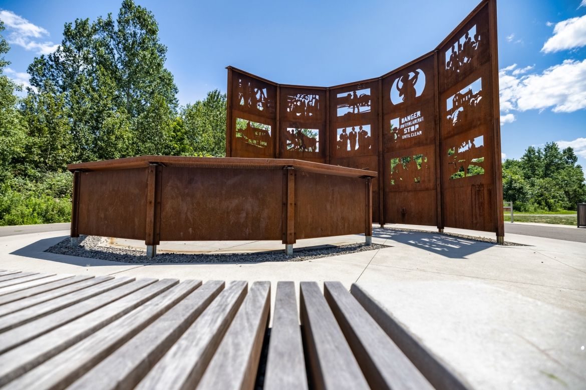 A corten steel art installation featuring images of significant historical events.