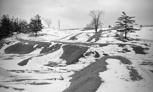 A snowy path going down a slope.