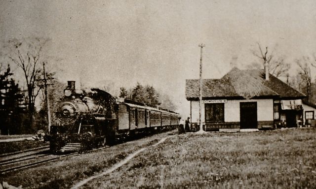 A black and white photo of a train passing through Downsview.