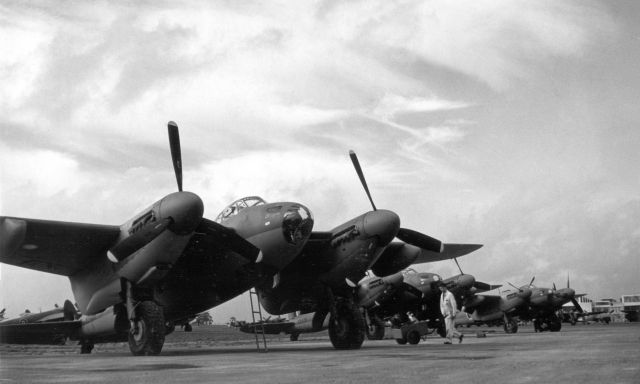 A black and white photo of five aircrafts, all de Havilland Mosquitos, standing in a row.