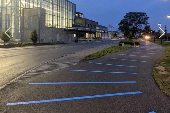 Bright blue lines painted along a paved path. Seneca college to the left.
