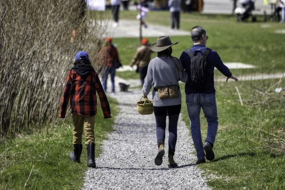 People walking on a path towards the Earth Day festival at Downsview Park.