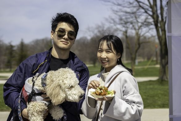 Two people and their dog smiling for the camera.