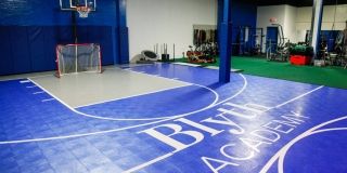 An indoor basketball court and weight training equipment.